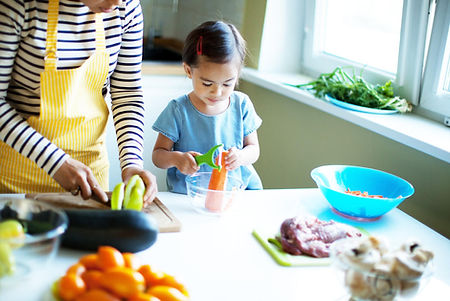 Young child and adult preparing fresh food.